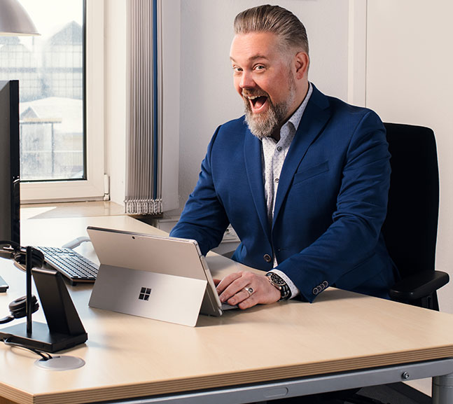 Mann am Schreibtisch vor Laptop