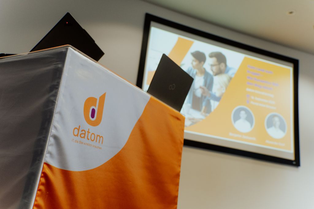 datom-Innovationstag_4 Ansicht Aufsteller datom und Folien im Hintergrund